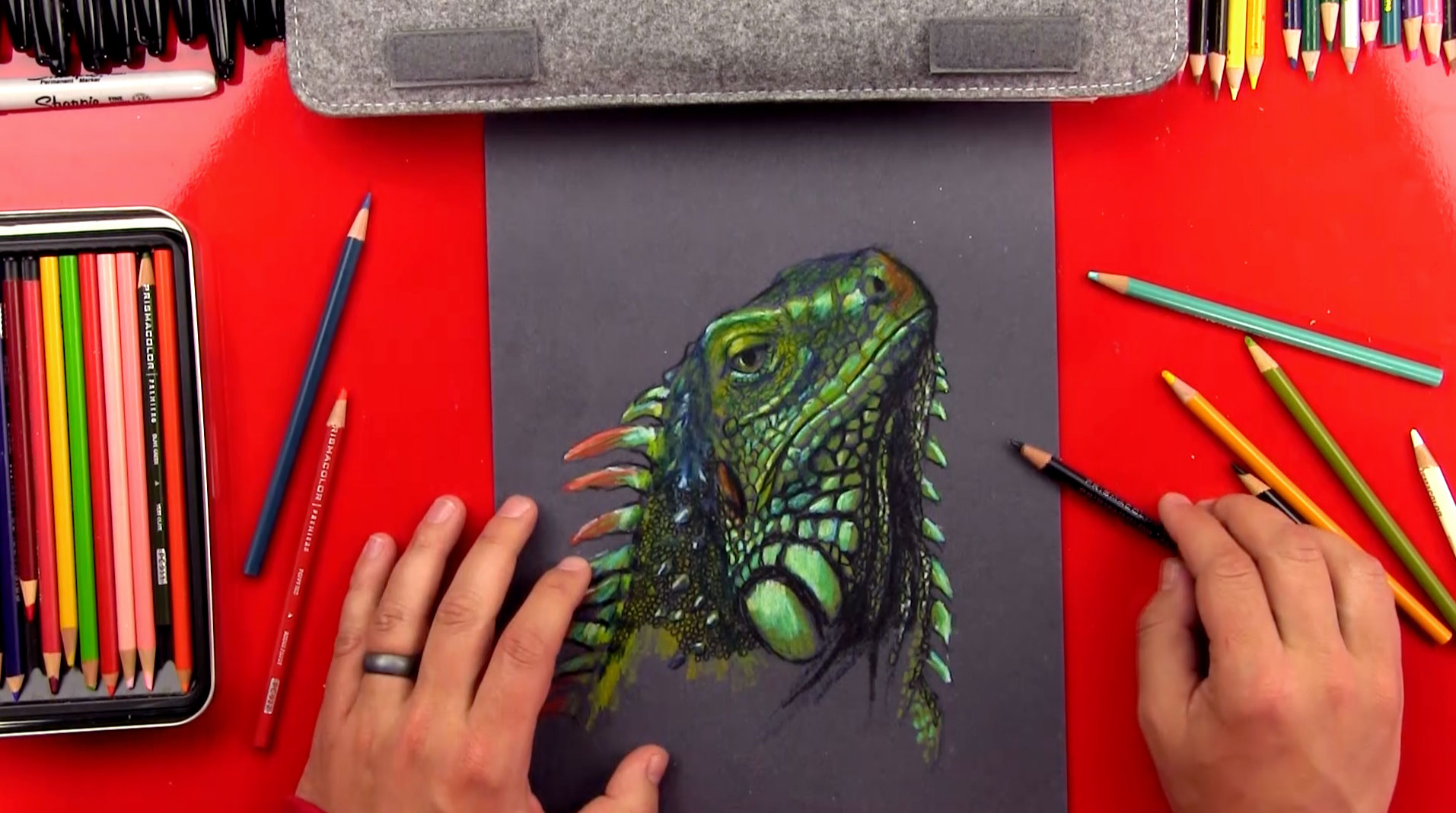 Iguana drawing on black paper.